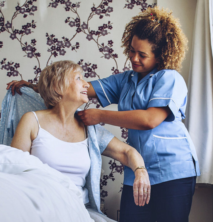 a female caregiver helping an elderly woman